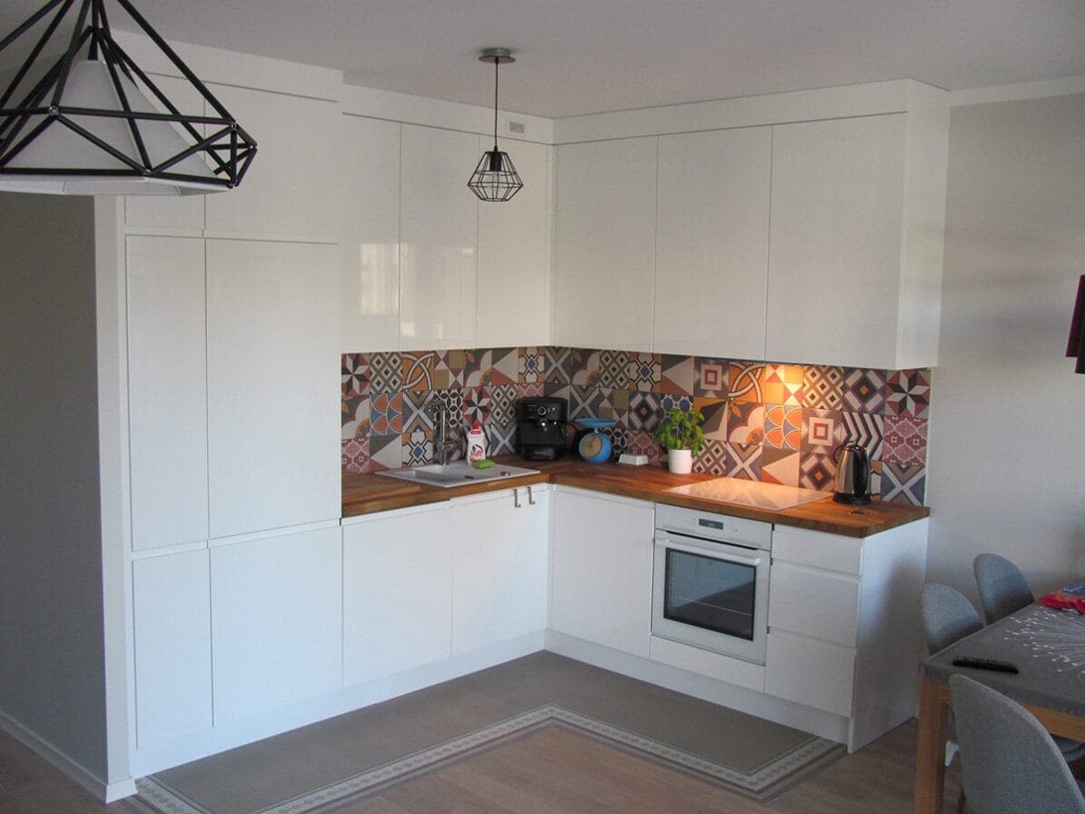 Nowoczesna biała kuchnia z patchworkowym szkłem nad blatem