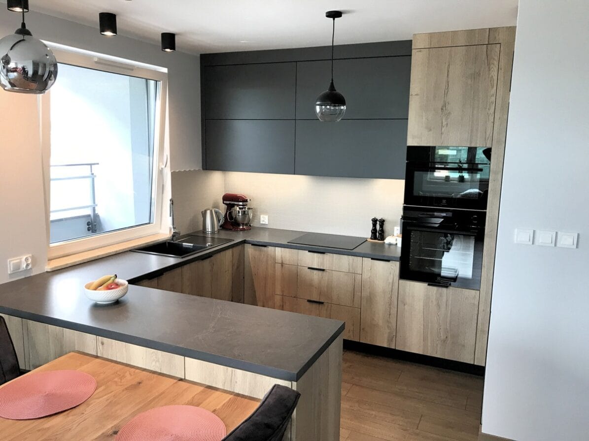 Realizacje 6 przestronna zabudowa kuchenna z wyspą i drewnianymi detalami